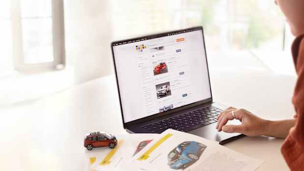 Eine Frau die an einem Laptop nach gebrauchten Elektro Autos recherchiert