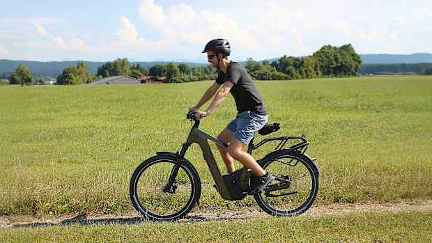 Ein Mann fährt das Riese & Müller Delite 5 GT Pinion Elektrofahrrad