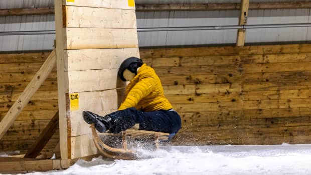 Ein Dummy mit Helm rast auf einem Schlitten gegen eine Wand beim ADAC Schlittencrashtest in der Skihalle in Bottrop