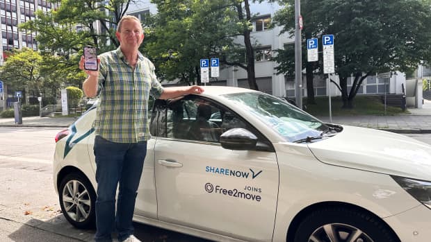 Christof Henn steht vor einem Carsharing Auto von Share Now