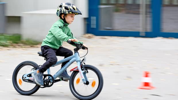 Ein Junge fährt auf einem 16 Zoll Fahrrad auf eine Pylone zu