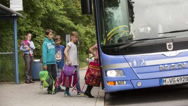 Kinder steigen in den Schulbus ein