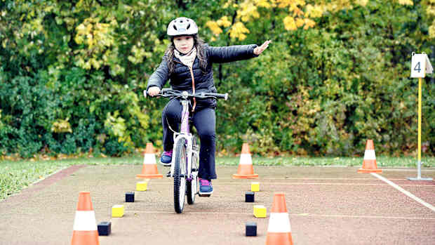 Ein Mädchen das sich Fahrrad fahren übt
