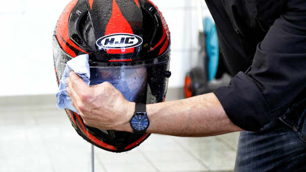 Das Visier eines Motorradhelms wird gereinigt