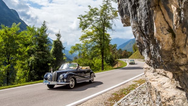 Ein Oldtimer vor einer Felswand beim ADAC Trentino Klassik