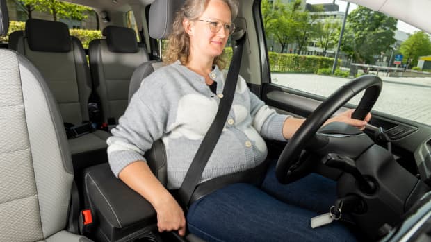 Eine Schwangere Frau sitzt in einem Auto