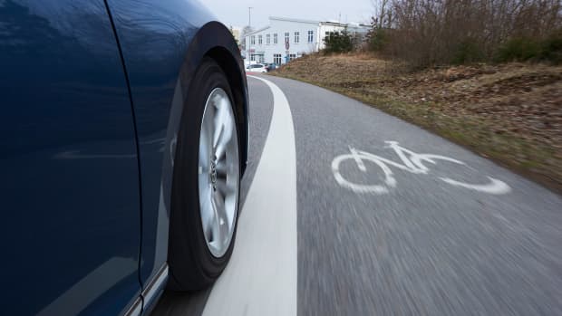 Ein Auto fährt neben einem Fahrradstreifen