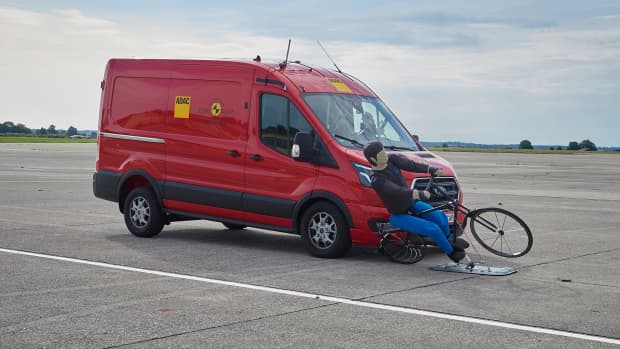 Ein Transporter fährt auf einen Fahrradfahrerdummy zu