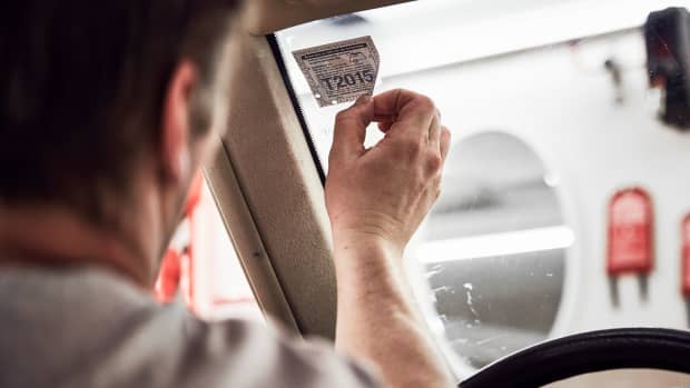 Eine Vignette wird mühsam von der Autoscheibe abgelöst