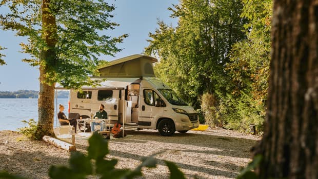 Ein Pärchen sitzt vor seinem Wohnmobil am Campingplatz Ambach
