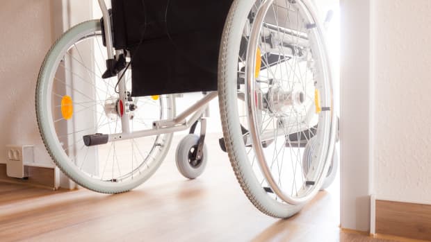 Ein Rollstuhlfahrer fährt durch eine barrierefreie Türe in einer Wohnung