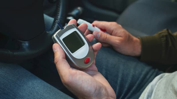 Glucometer und Lanzenstift in den Händen eines Mannes