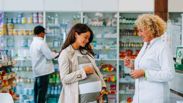 Eine schwangere Frau in einer Apotheke
