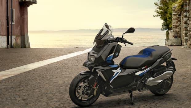 Der BMW C 400 X Scooter an einem See auf Kopfsteinpflaster