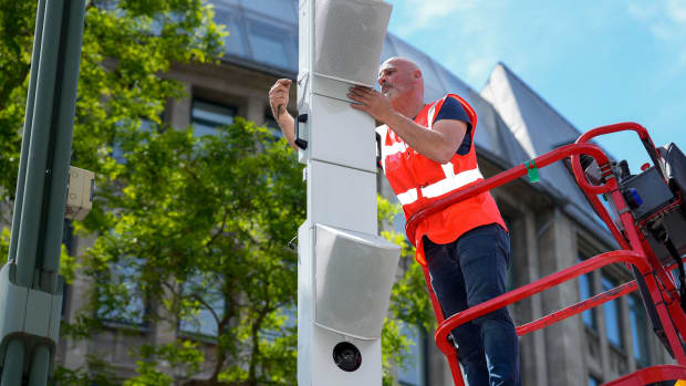 Ein Mann installiert am Kudamm in Berlin einen Lärmblitzer