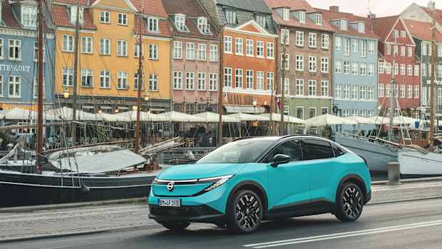 Der Nissan Leaf mit buten Häusern im Hintergrund