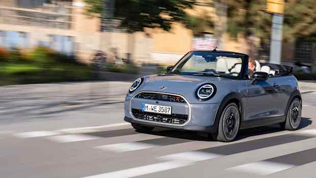 Front und Seitenansicht eines fahrenden Mini Cooper Cabrio