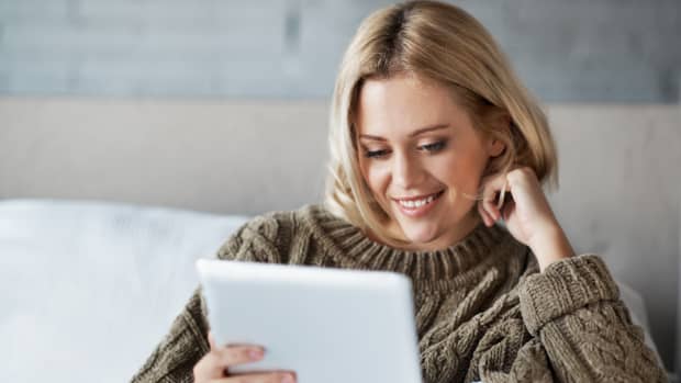 junge Frau liesst auf einem Tablet