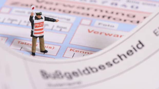 Ein Spielzeugpolizist steht auf einem Bußgeldbescheid