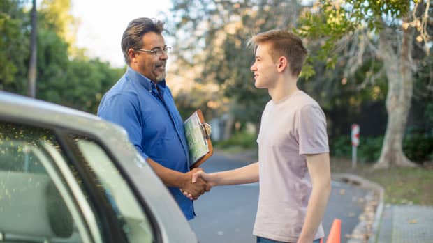 Fahrlehrer gratuliert Schüler zur bestandenen Führerscheinprüfung