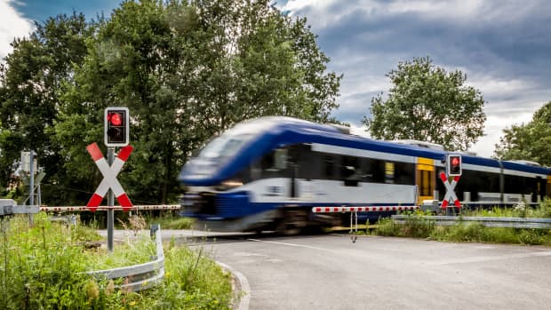 Zug fährt über Bahnübergang
