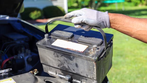 Mann entnimmt Batterie aus dem Auto