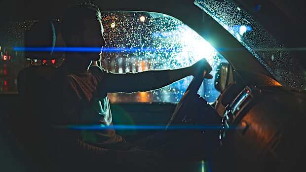Ein Mann wird nachts beim Autofahren geblendet
