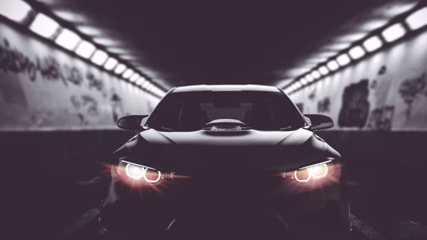 Ein schwarzes Auto leuchtet mit LED Scheinwerfern in einem Tunnel