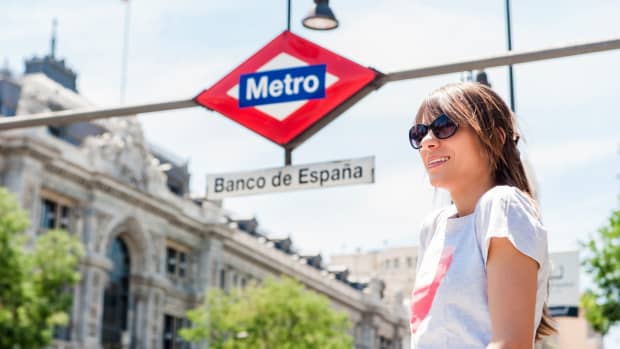 Eine junge Frau wartet an einer U-Bahn Station in Madrid