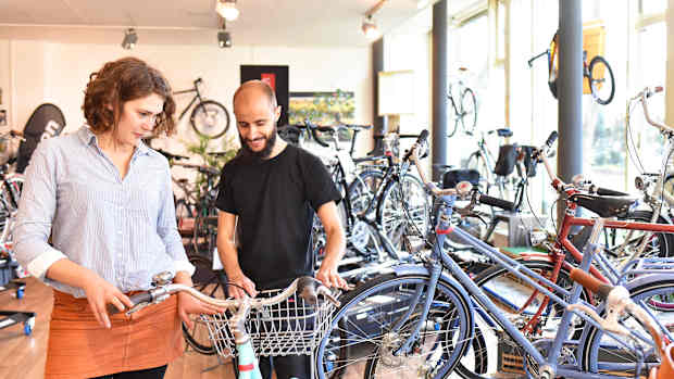Eine Frau kauft ein Fahrrad in einem Fahrradladen