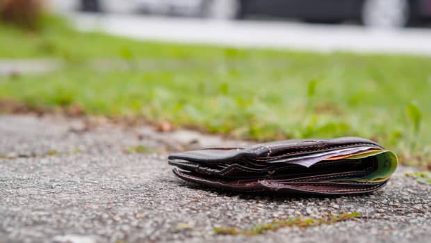 Eine mit Geld gefüllte Geldbörse liegt verloren auf der Strasse