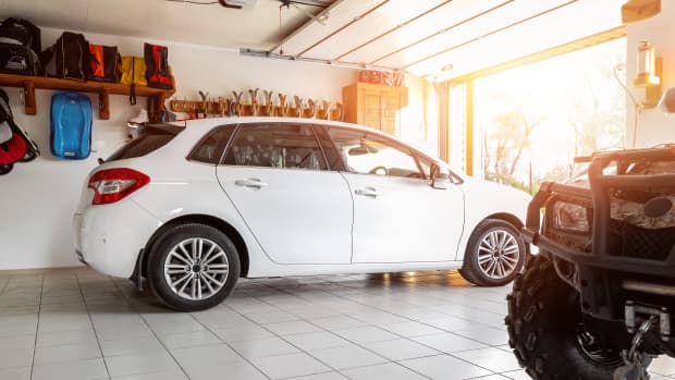 Blick in eine Garage mit einem weißen Kombi und einem Quad