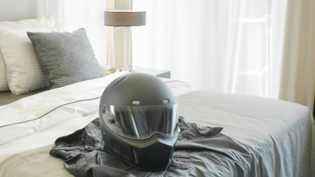 Ein Motorradhelm liegt auf einem Hotelbett