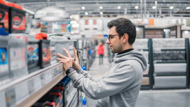 Mann kauft eine Autobatterie