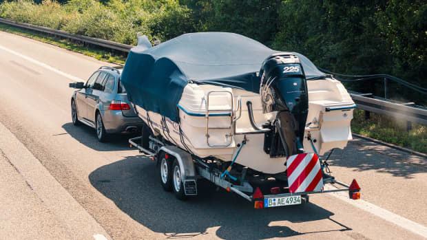 Ein grauer PKW mit einem Bootsanhänger und grünem Kennzeichen