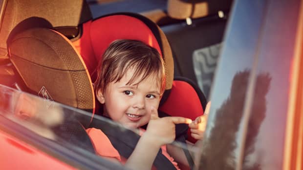 Kleiner Junge sitzt in Kindersitz auf der Rückbank