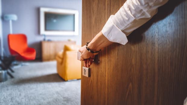 Mann öffnet Tür zu Hotelzimmer