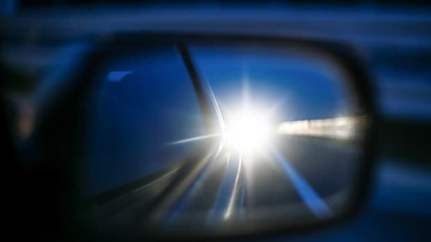 Lichthupe im Rückspiegel eines Autos