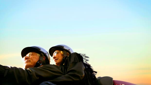 Ein Paar fährt mit Helm und Brille Motorrad