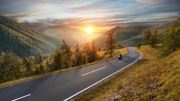 Motorradfahrer auf einer Passstraße im Herbst