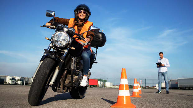 Eine Fahrschülerin sitzt auf einem Motorrad auf einer Teststrecke