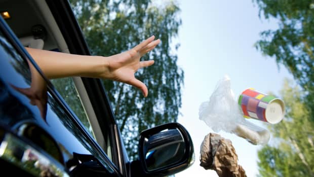 Frau wirft Kaffeebecher und Müll aus dem Fenster eines fahrenden Autos