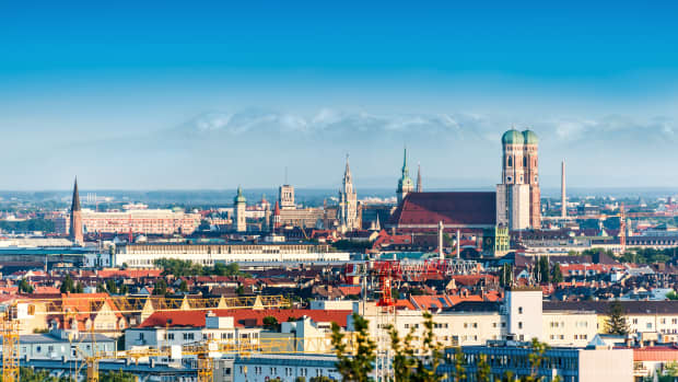 Panoramaansicht von München mit der Frauenkirche und im Hintergrund sieht man die Alpen