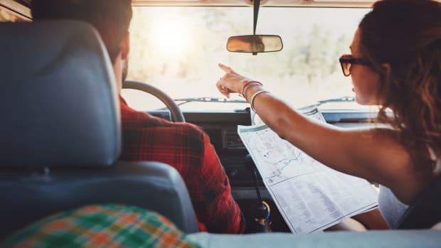Frau weißt Mann Weg mit Landkarte im Auto