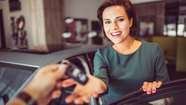 Eine Frau nimmt einen Autoschlüssel entgegen