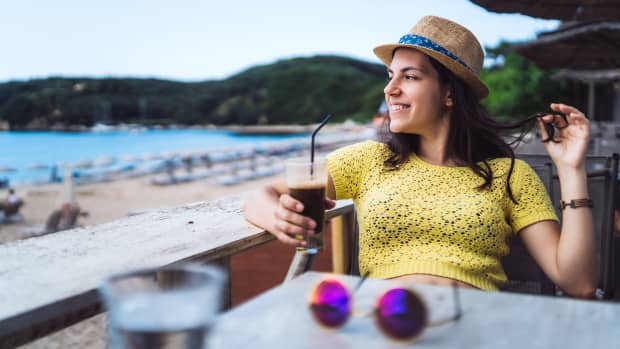 Eine Frau trinkt einen Eiskaffee am Strand