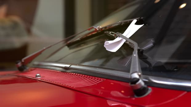 Ein Strafzettel hängt an der Autoscheibe