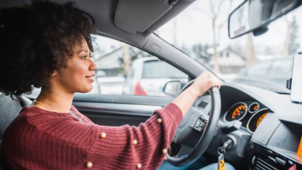 fröhliche Frau am Steuer Ihres Autos