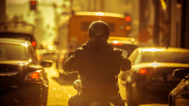Motorradfahrer schlängelt sich durch Stau
