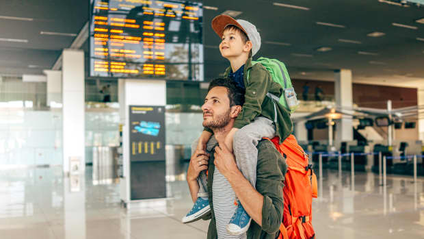 Vater trägt Kind auf der Schulter am Flughafen